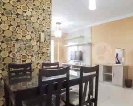 Area makan dengan meja makan kayu dan dekorasi dinding.