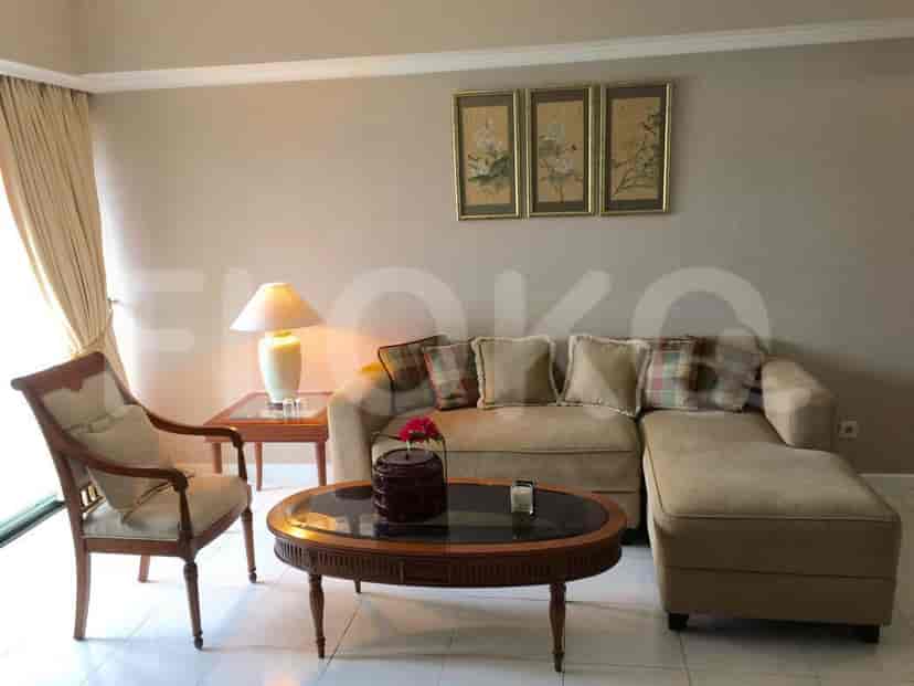 A cozy living room with a beige sectional sofa, decorative art, and a round coffee table.