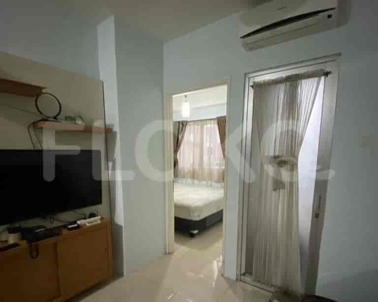A living room area, with the open doorway to a bedroom.