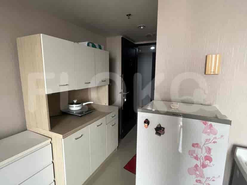 A small kitchenette with cabinets, appliances, and a stovetop.