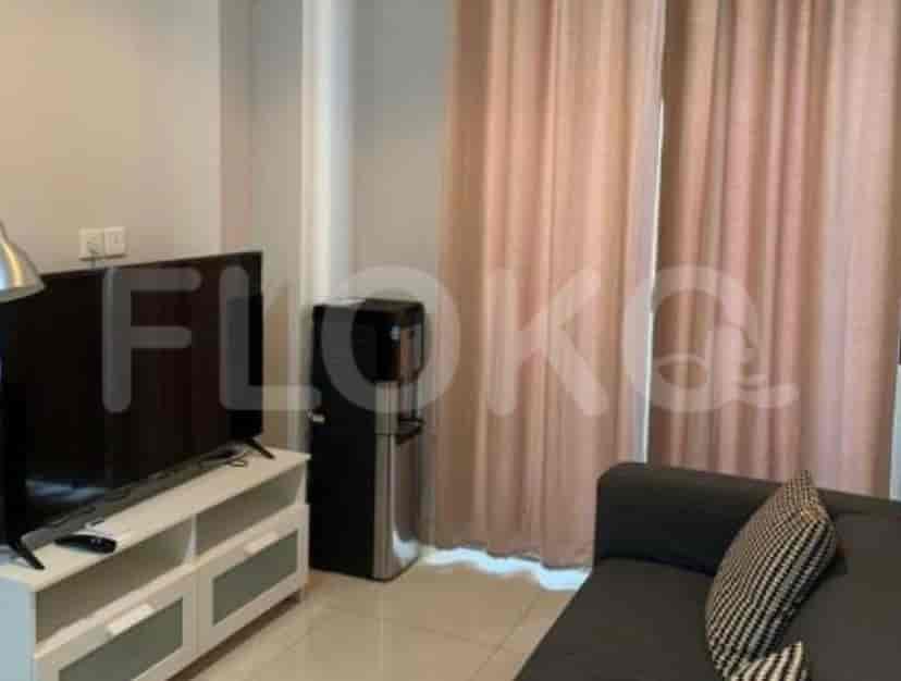Living room with TV, water dispenser and sofa.