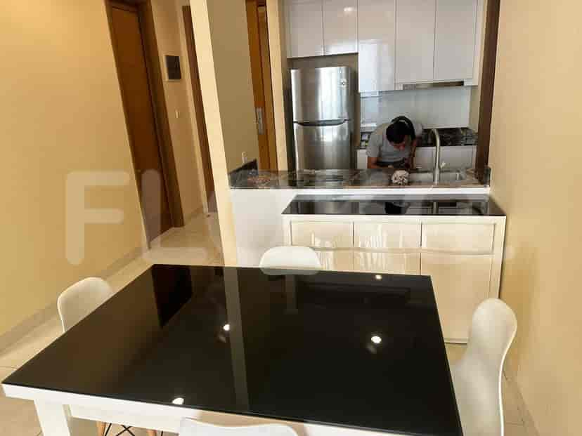 Area makan dengan meja hitam dan dapur.