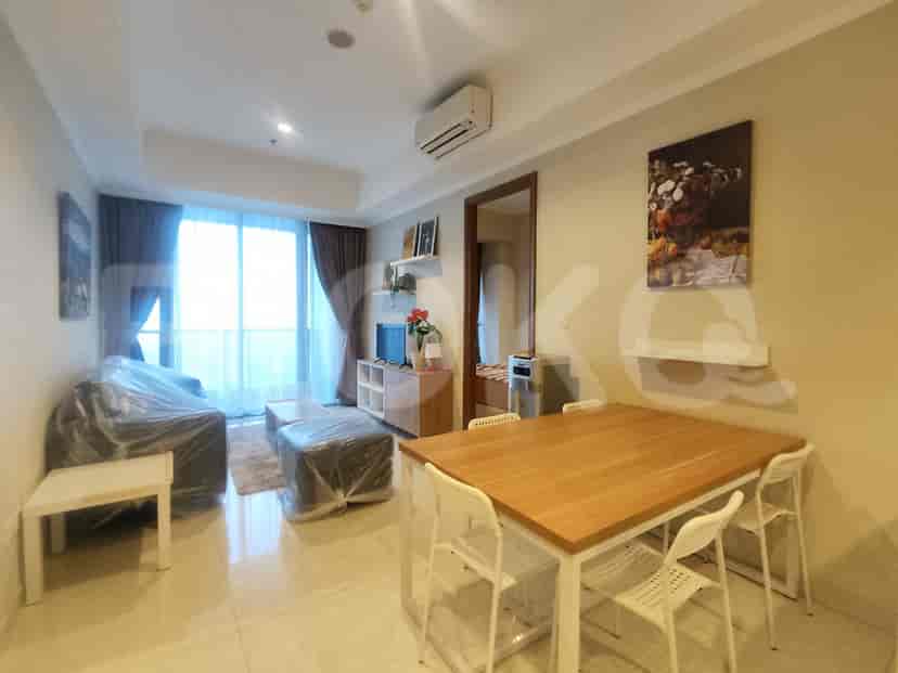 Ruang tamu dan ruang makan dengan sofa, meja makan, dan dapur yang terhubung.