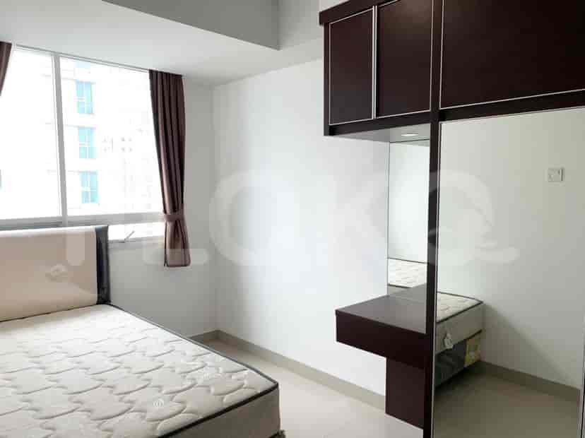 A second bedroom with a single bed, wardrobe, and a large window.