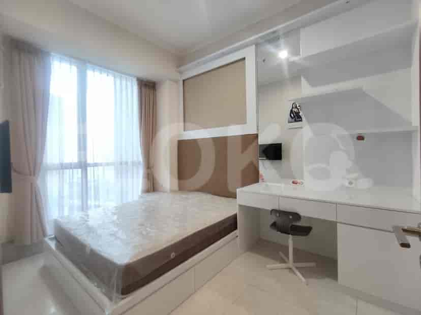 Bedroom with a bed, desk, and large windows.