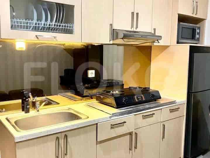 A functional kitchen with cabinets, appliances, and mirrored backsplash.