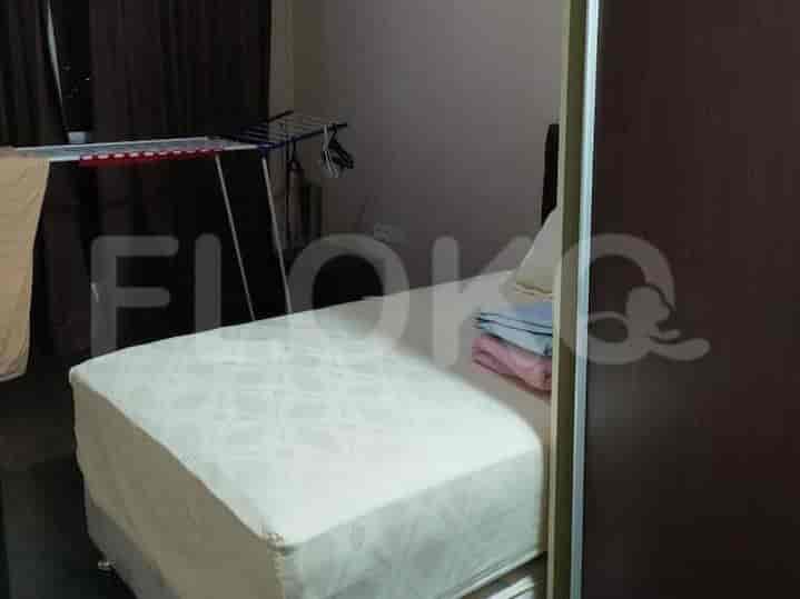 A second bedroom featuring a bed and a clothes drying rack.