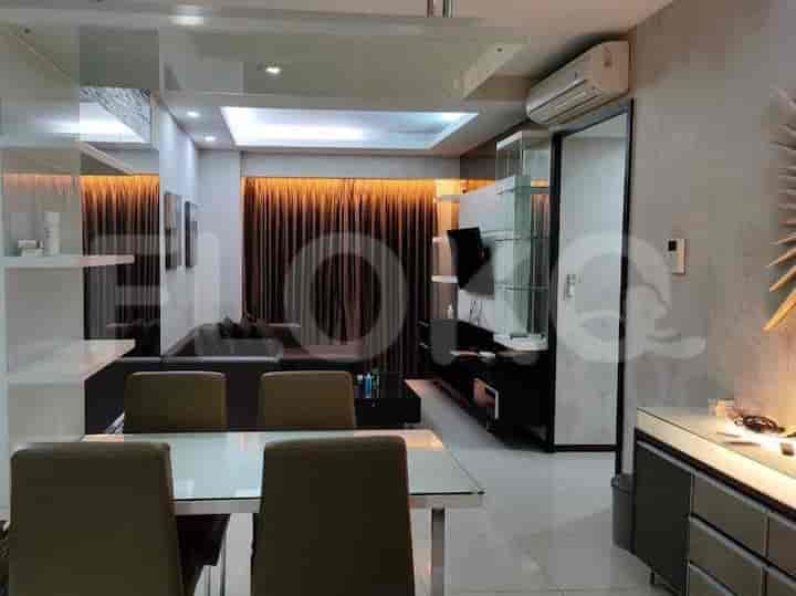 A modern living and dining space with a dining table, sofa, and TV.