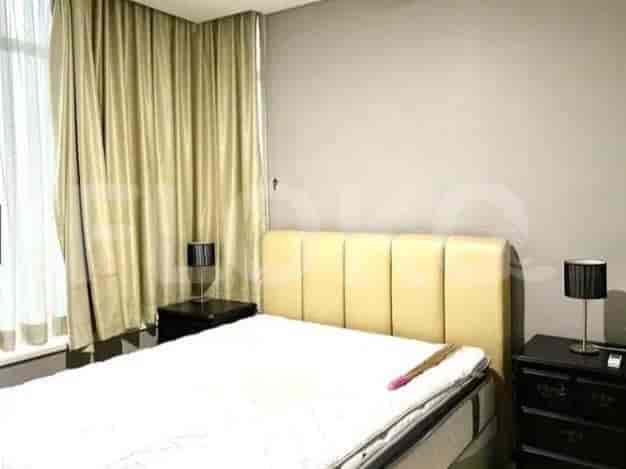 A bedroom featuring a bed, nightstands with lamps, and curtains.