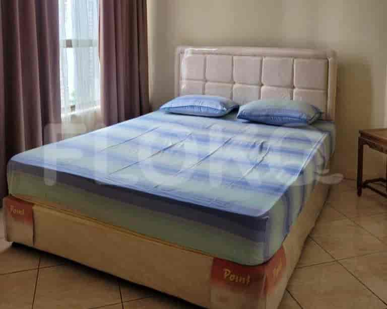 A bedroom featuring a double bed with a quilted headboard.