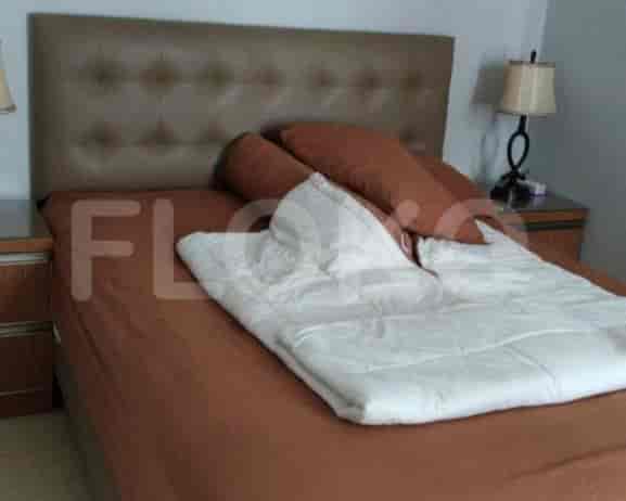 A bedroom with a large bed and headboard.