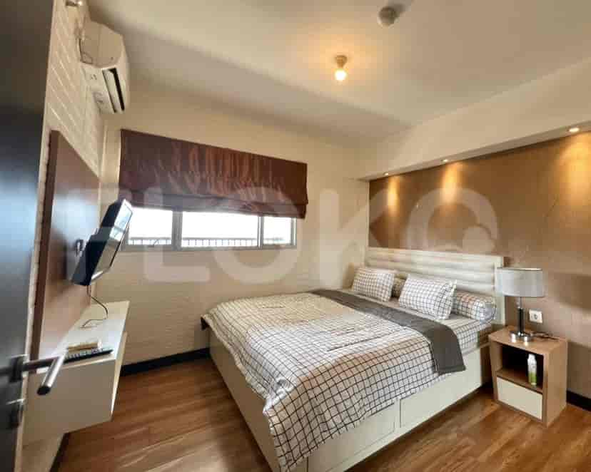 Kamar tidur dengan tempat tidur, TV, dan jendela.