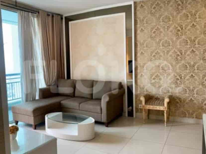 Ruang tamu luas dengan sofa sectional, meja kopi, dan kursi samping.