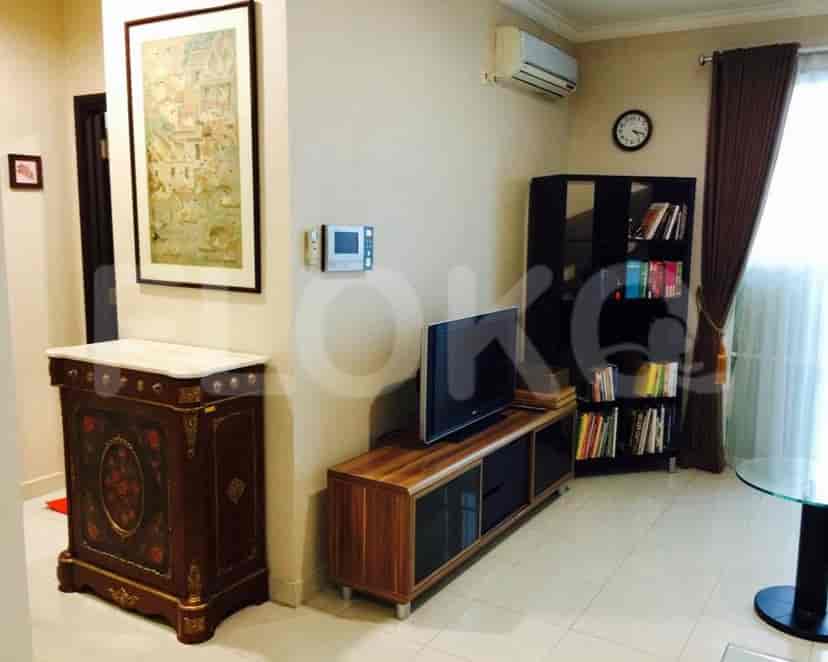 Living room with a dark cabinet, a smart TV, and a bookshelf.