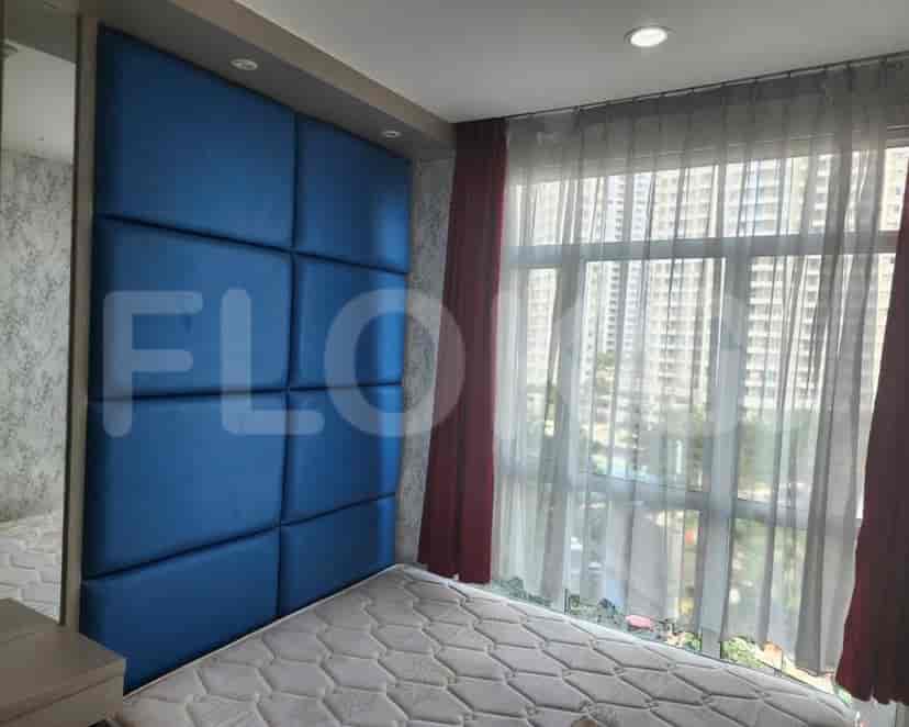 Kamar tidur menampilkan sandaran kepala berlapis biru dan jendela besar.