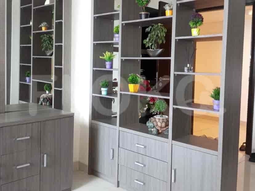 Modern room with grey shelves, plants, and decorative items.
