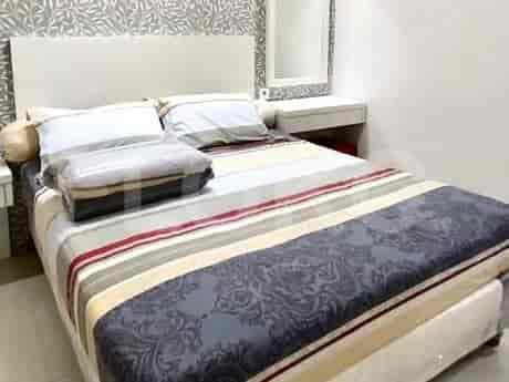 A bedroom with a bed and patterned duvet