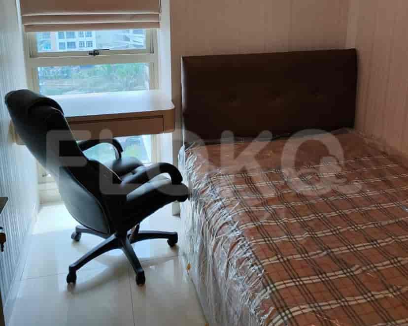 A bedroom with a bed, desk, and chair near a window.