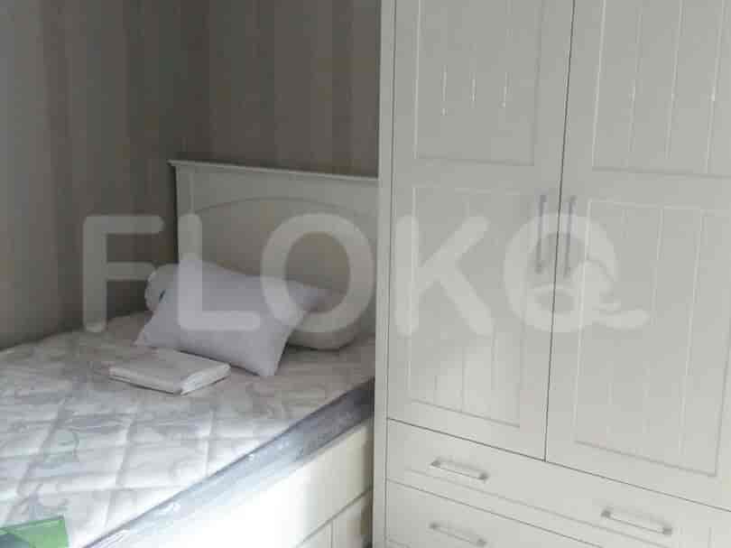 A small bedroom with a single bed, a white wardrobe, and wallpaper.