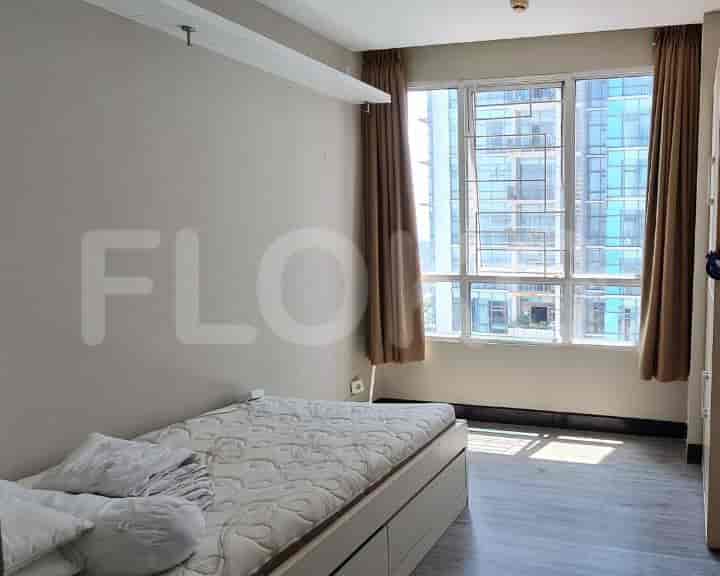 A bedroom with a single bed, window with curtains, and neutral walls.