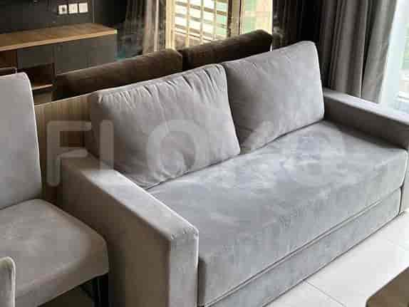 A modern living room with a grey sofa and a view of the city.