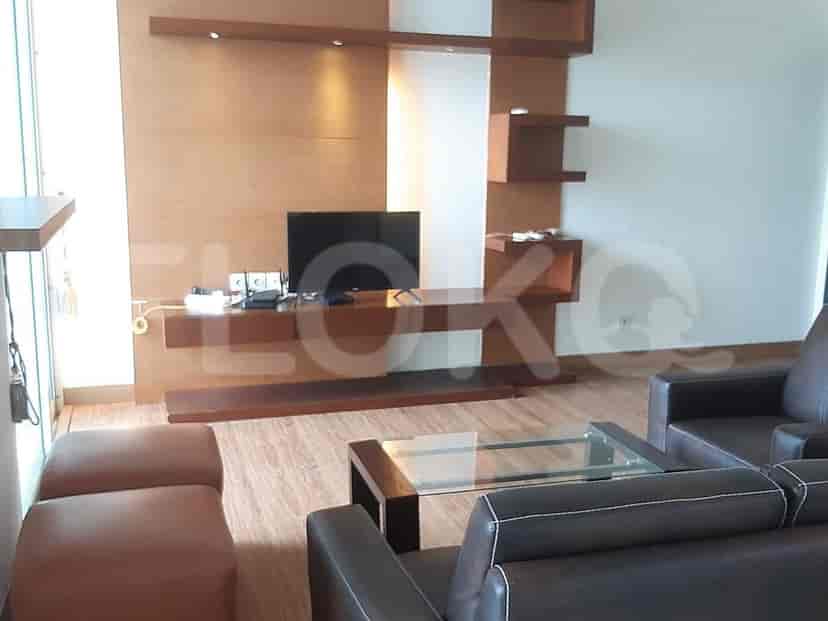 Modern living room with a TV, seating, and wooden accents.