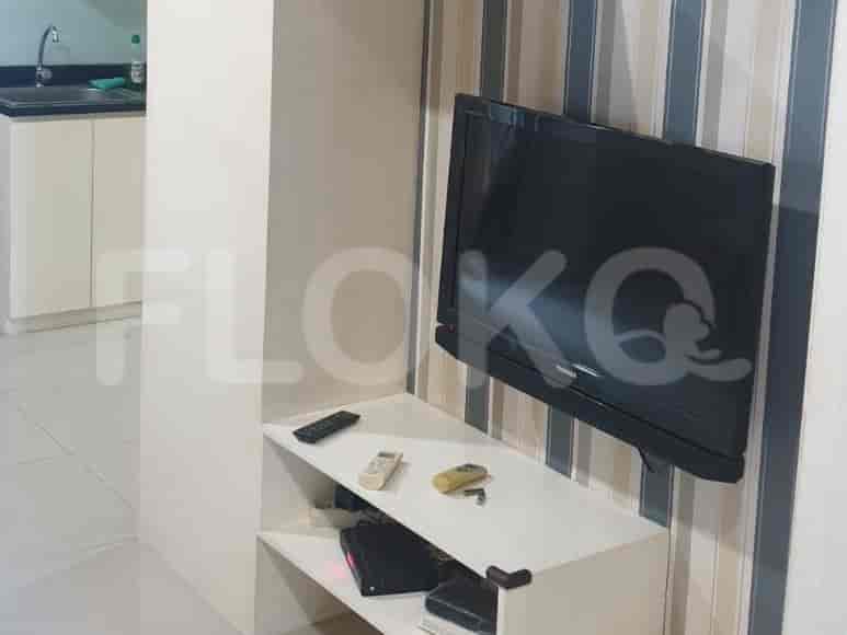 TV yang dipasang di dinding dengan unit hiburan.