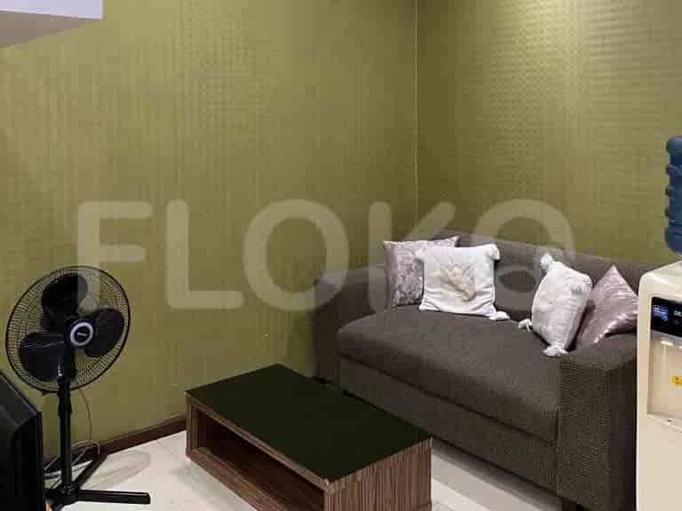 Living room with a brown sofa, fan, and coffee table.