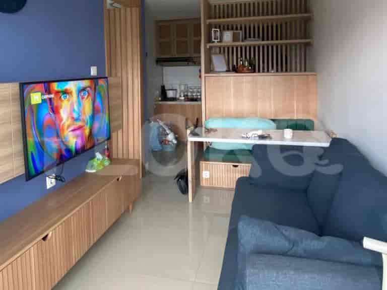 Living area showing a TV, seating area and a table with bench.