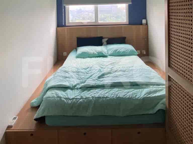 Bedroom with a queen bed and wooden storage.