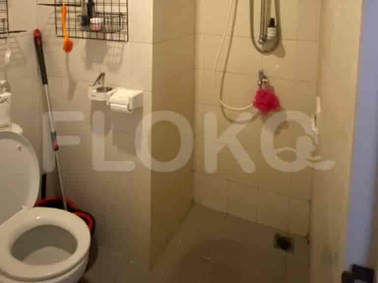 Small bathroom with a toilet, sink and shower area.