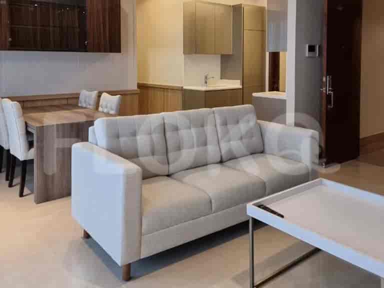 Ruang tamu dan ruang makan modern, menampilkan sofa abu-abu muda, meja makan, dan pemandangan ke dapur.