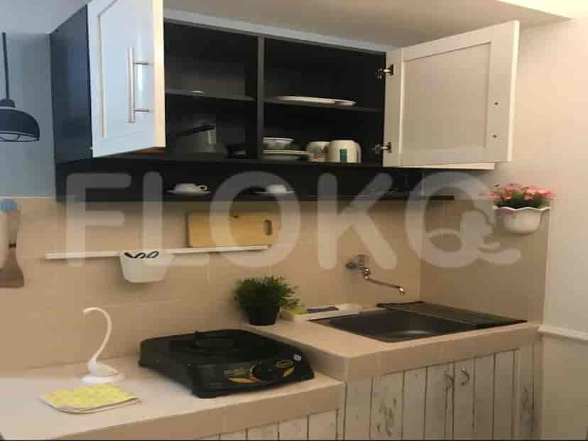 Compact kitchen with white and black cabinets and a gas stove.