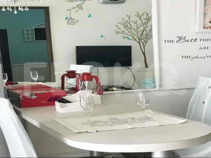 Dining table with decorations and a reflection showing the living area and kitchen.