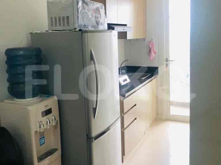 A modern kitchen with appliances including a refrigerator and water dispenser.