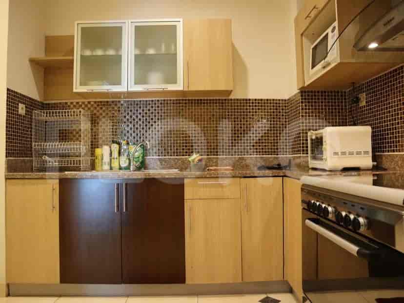 A modern kitchen with light-colored cabinets, a stove, and a microwave.