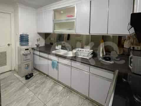 A modern kitchen with white cabinets, a water dispenser, and a sink.