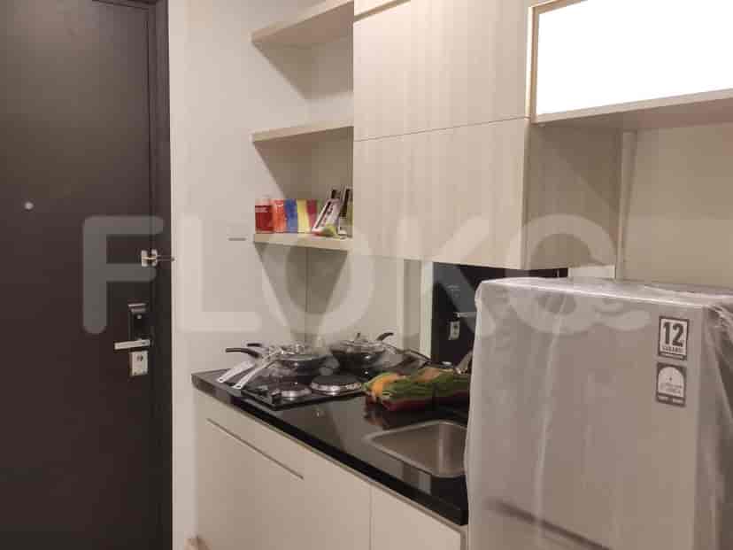 A small kitchenette with a refrigerator, microwave, and cooking surface.