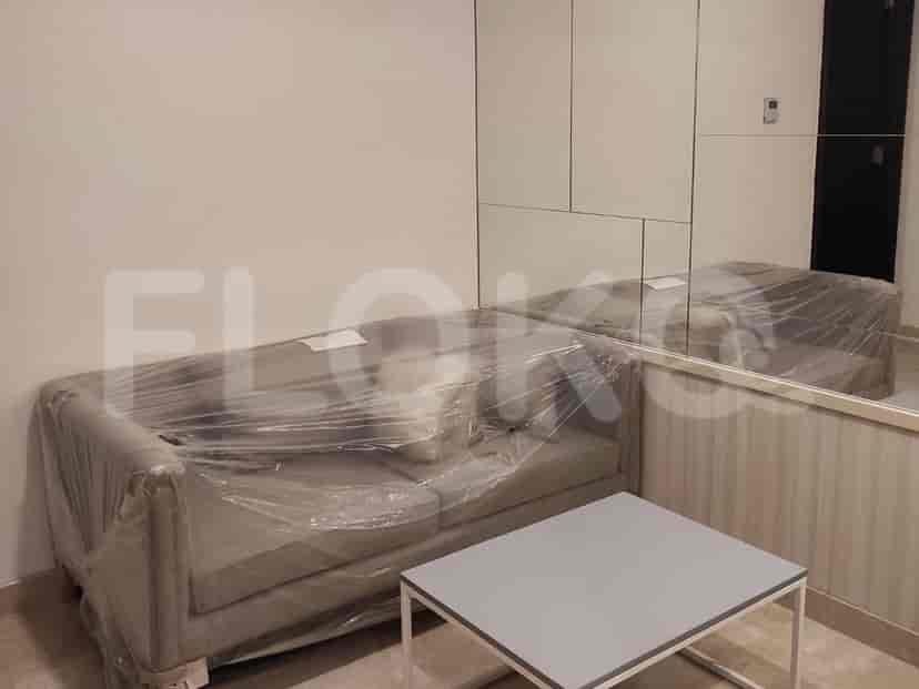 A modern living room with a grey sofa, a coffee table, and a mirror.