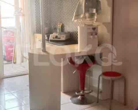 A kitchenette with a bar-style counter, stools, and a water dispenser.