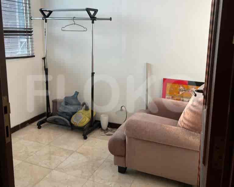 A walk-in closet with a clothing rack and a chair.