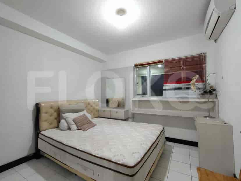 A bedroom with a queen-sized bed and a dressing table.