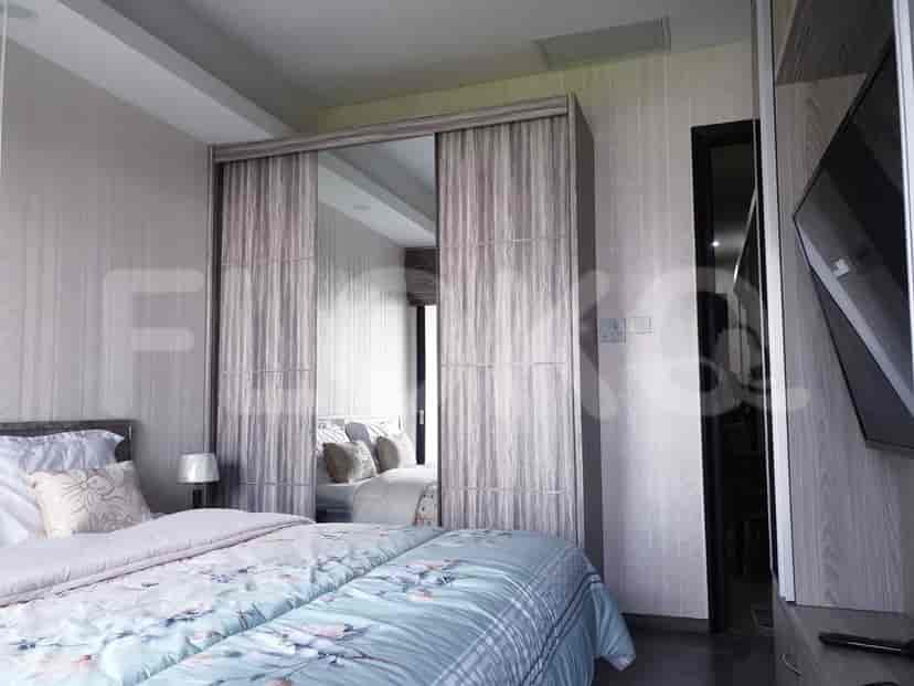 A bedroom featuring a bed with a patterned duvet and a large mirrored closet.