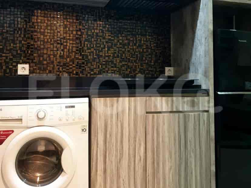 A modern kitchen with wooden cabinets, a washing machine, and tiled backsplash.