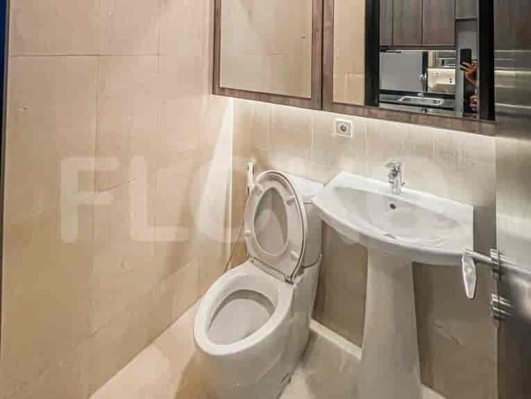 A modern bathroom with a white toilet, sink, and mirror.