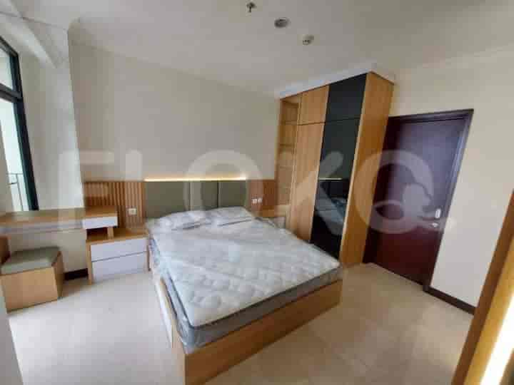 A well-lit bedroom with a double bed, large wardrobe, and wooden accents.