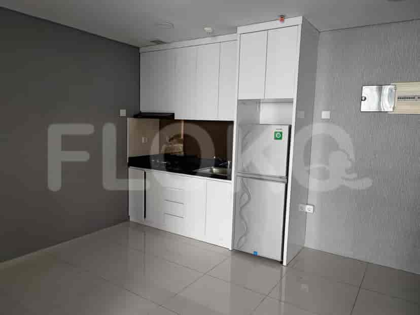 Dapur modern dengan lemari putih, lemari es, dan meja dapur gelap.