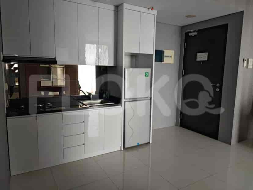 Dapur modern dengan lemari putih, lemari es, dan meja dapur gelap.
