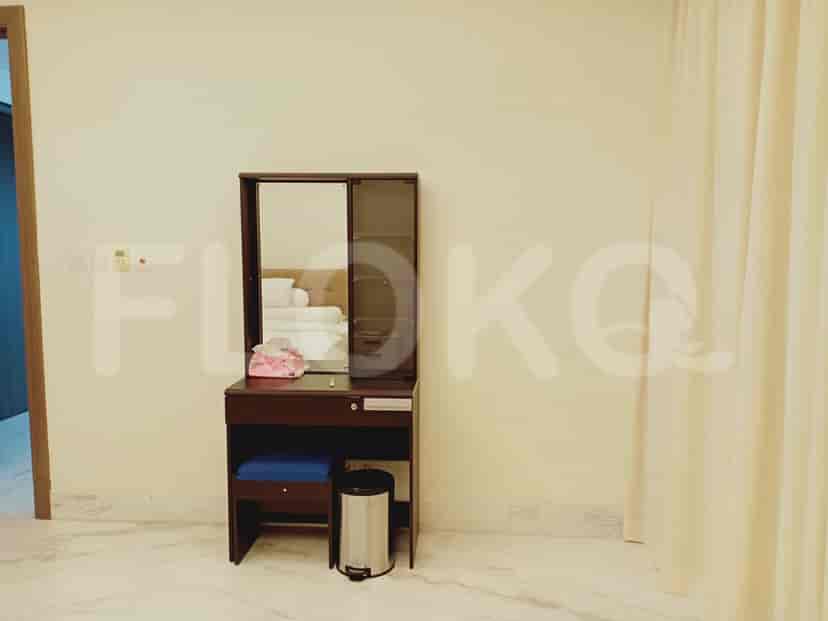 Vanity area with mirror, stool, and a small trash can.