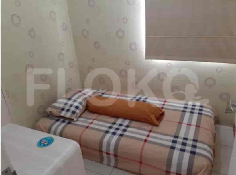 A small bedroom with a single bed and a patterned bedspread.